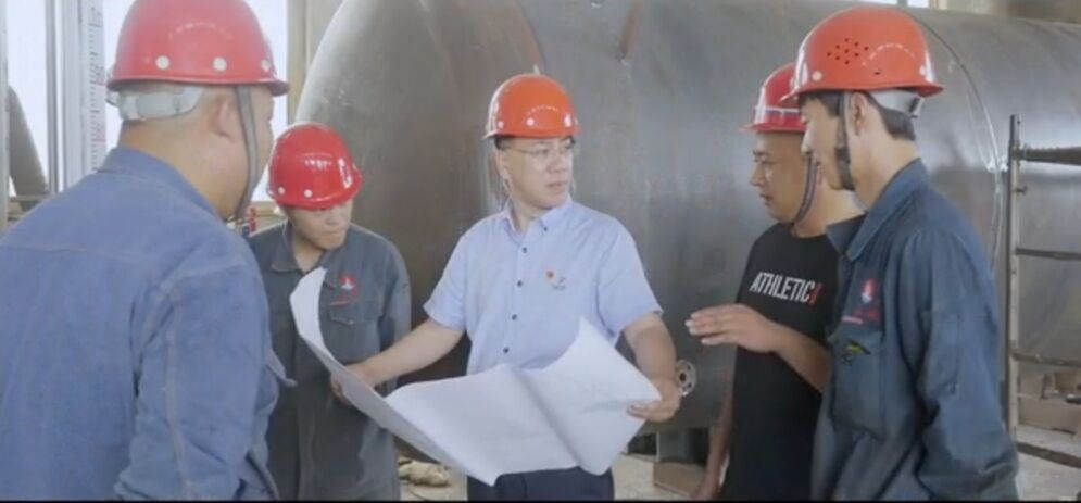 董事长何乃昌在车间与技术员探讨问题